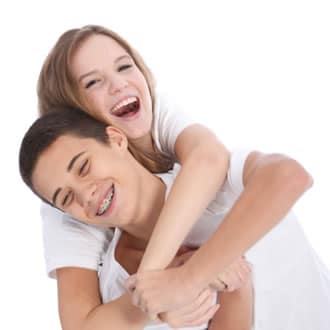 A sister riding on her brother's back against a white background.
