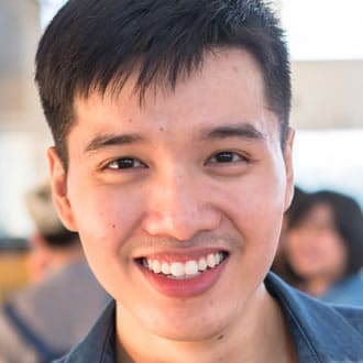 A boy with black hair smiling.
