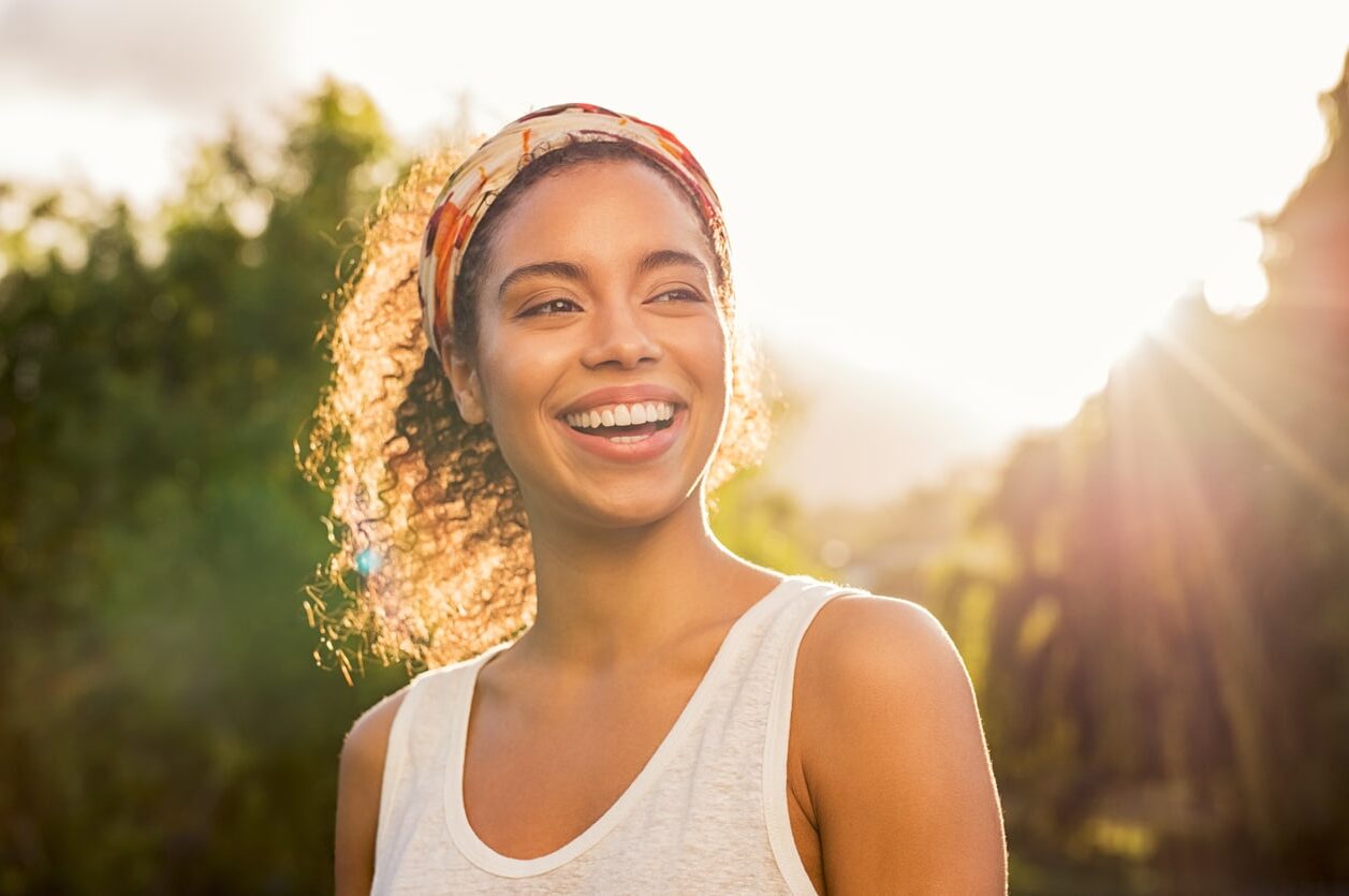 A young woman smiling in the sun.