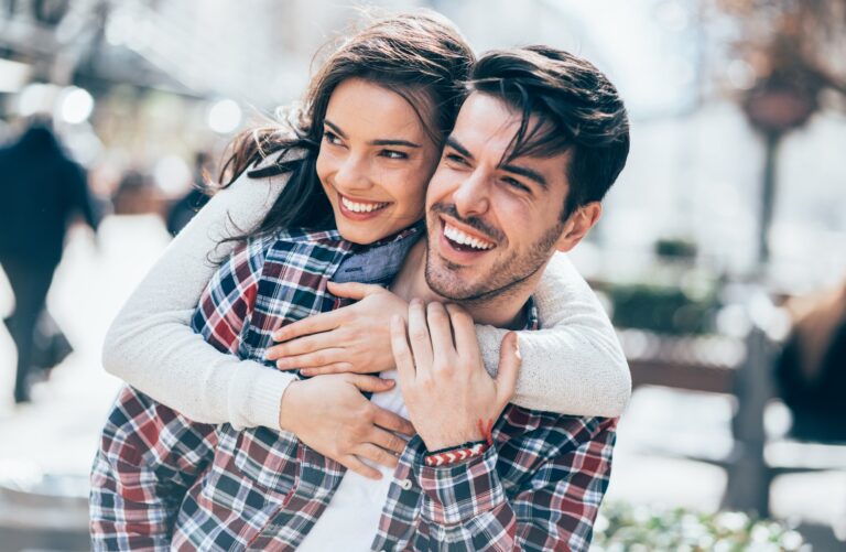 Woman embracing her boyfriend from behind on a spring day