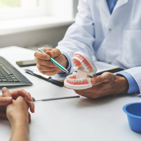 dentist and patient discussion about planned teeth treatment in dental clinic office